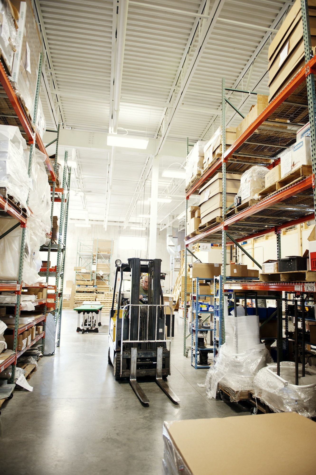 Man Travelling In Forklift At Warehouse